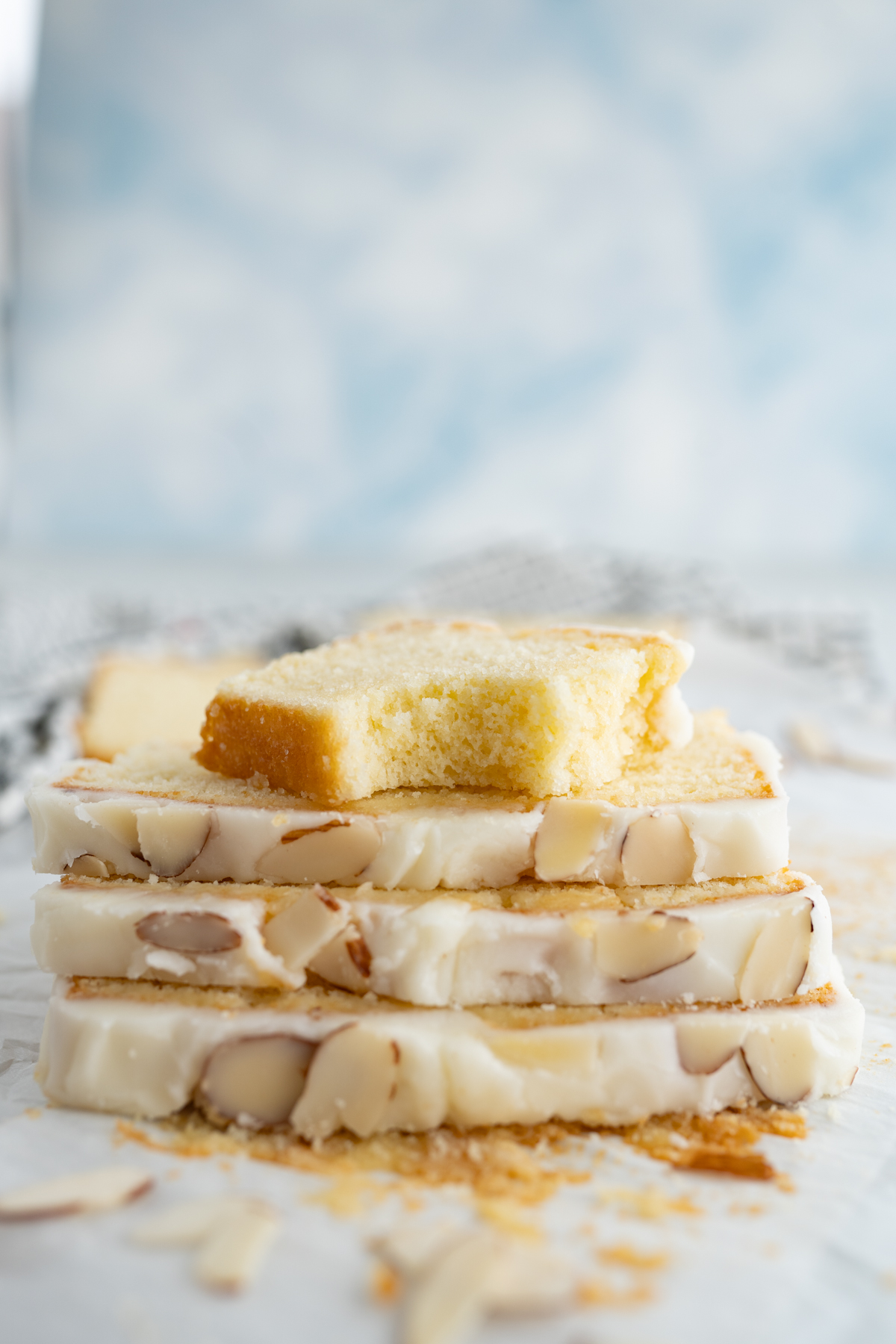 Side view of glazed almond pound cake slices stacked. 