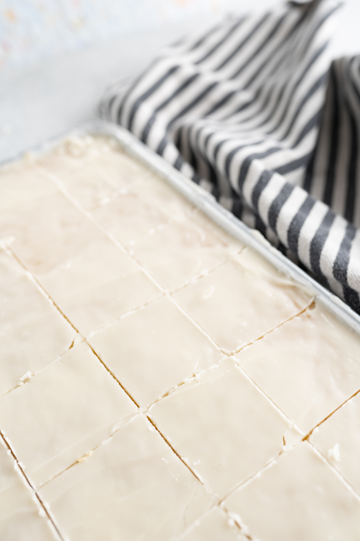 Aerial view of a vanilla sheet cake cut into squares. 