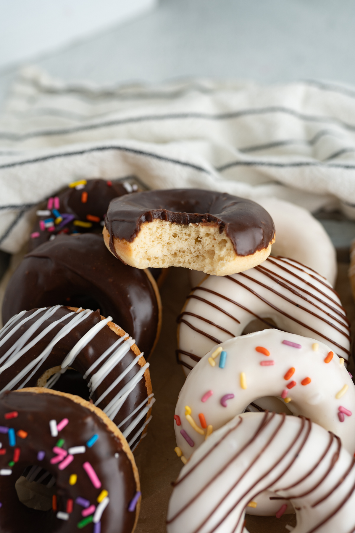A baked cake donut with a bite taken out of it. 